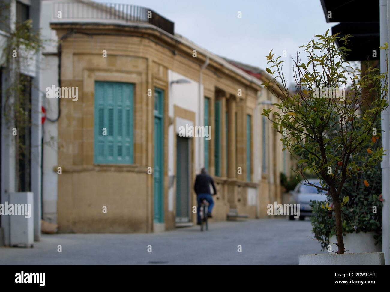 Μan à vélo portant sa paire de jeans bleus dans les rues étroites de la vieille ville de Nicosie Chypre. Heure : décembre 2020 Banque D'Images