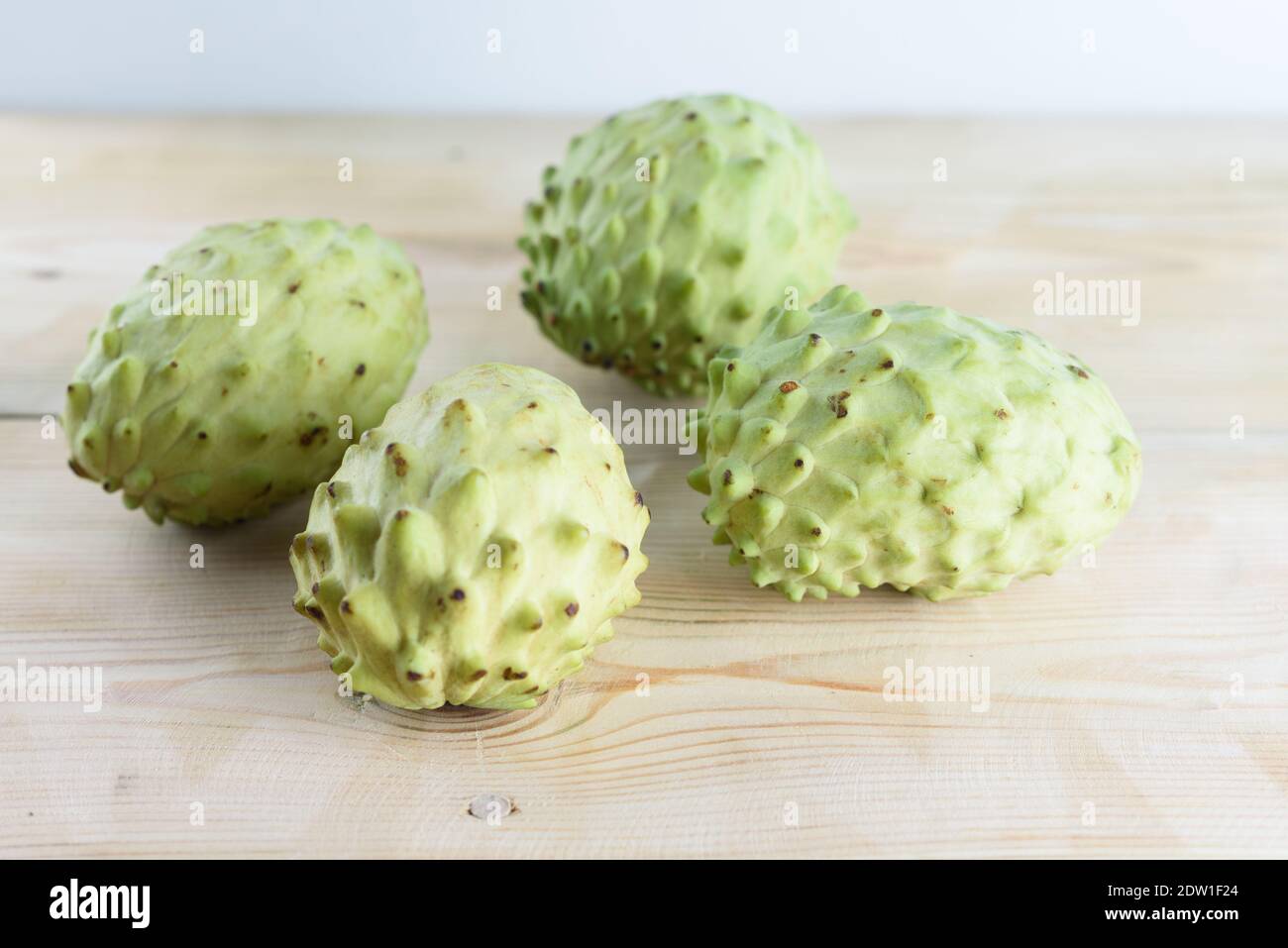 L'annona, l'Anone, le Chérimoye, sucre Pomme sur fond de table en bois. Annona muricata et d'autres plantes ont démontré des composés prometteurs qui peuvent être utilisés dans le traitement du cancer. Banque D'Images
