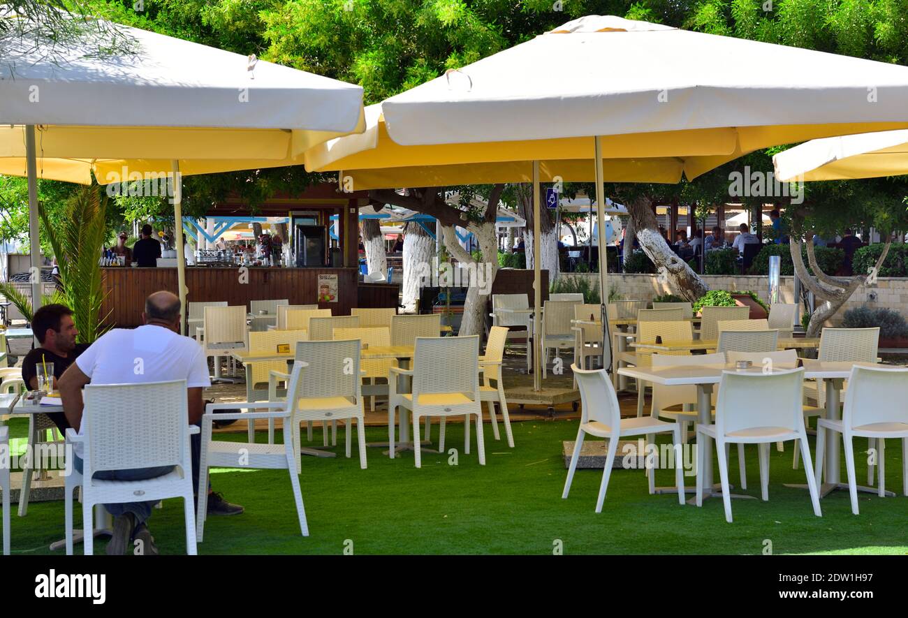 Tables et chaises extérieures pour dîner sous les parasols au Dasoudi Restaurant by Beach, Limassol, Chypre Banque D'Images