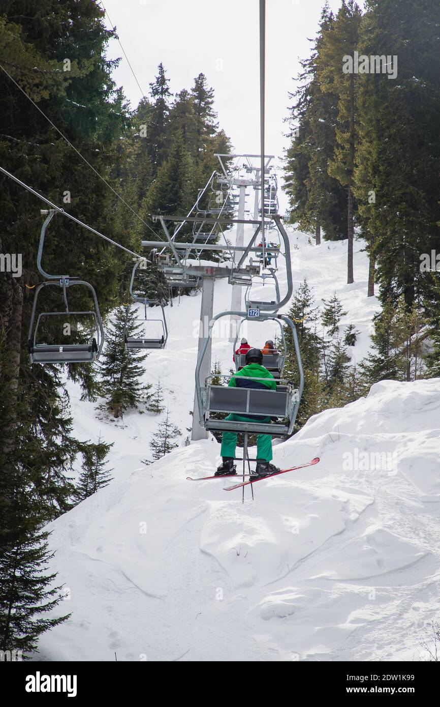 Homme avec ski sur le télésiège, se rendant aux sept lacs de Rila, Bulgarie. Banque D'Images