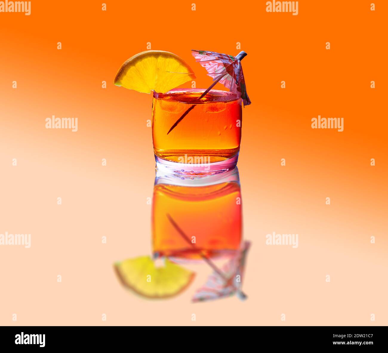Boisson tropicale froide avec glace, tranche d'orange et parasol sur fond  orange avec réflexion Photo Stock - Alamy