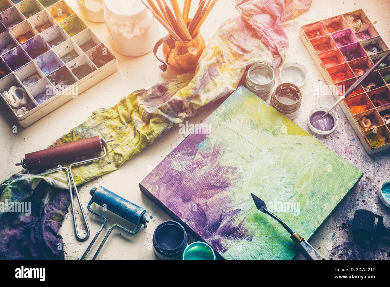 Équipement artistique - couteau à toile et à palette, pinceaux, peintures multicolores dans un studio d'artistes. Vue de dessus. Banque D'Images
