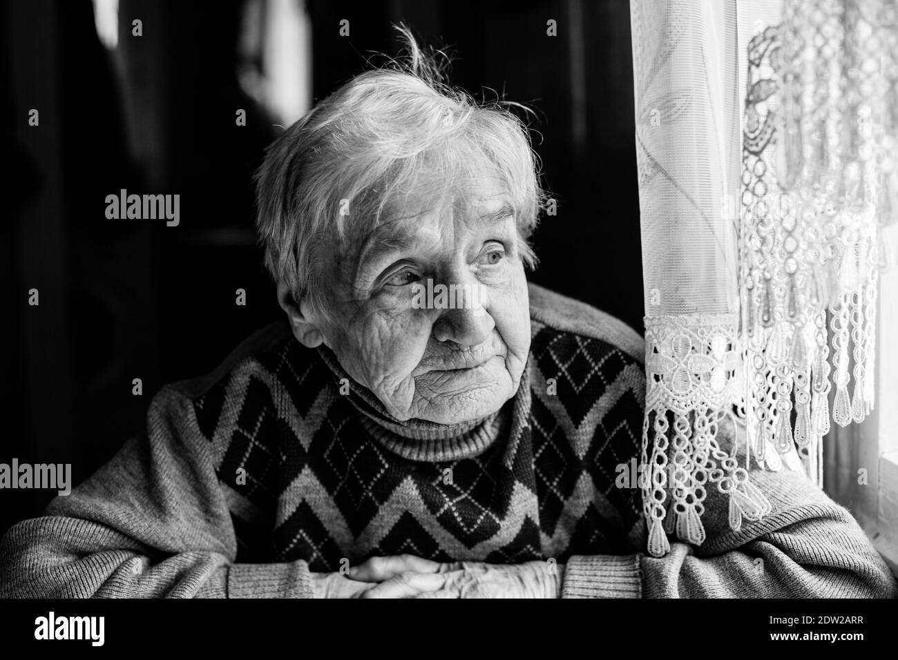 Portrait d'une vieille femme dans sa maison. Photo en noir et blanc. Banque D'Images