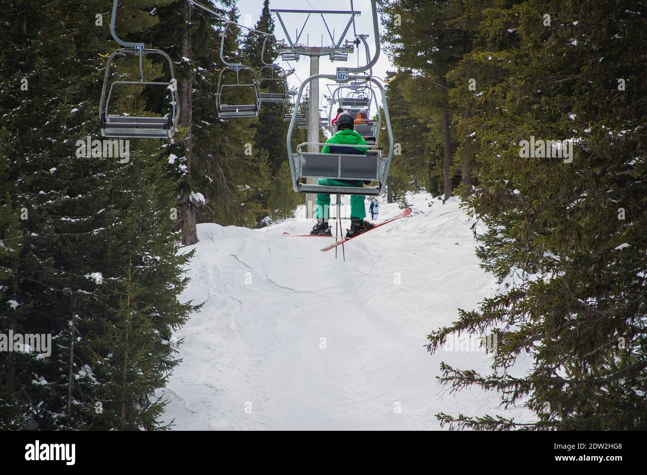 Homme avec ski sur le télésiège, se rendant aux sept lacs de Rila, Bulgarie. Banque D'Images