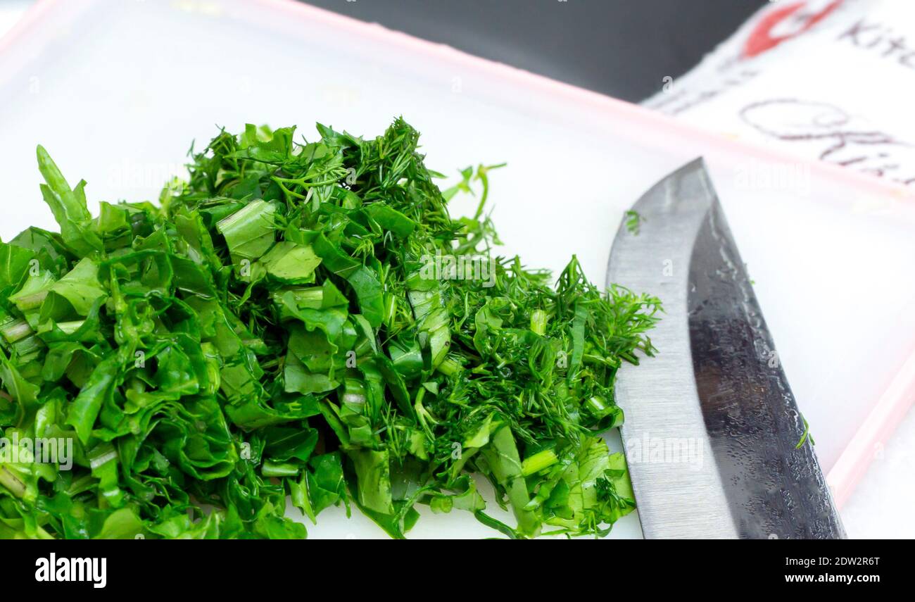 Persil haché et herbes d'arugula avec couteau pour salade verte Photo Stock  - Alamy
