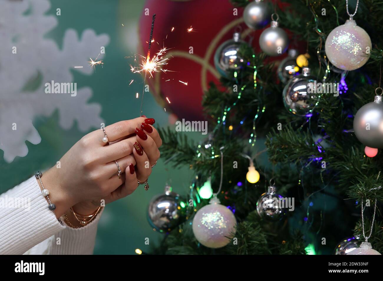 Girl holding a burning sparkler in her hands. Banque D'Images