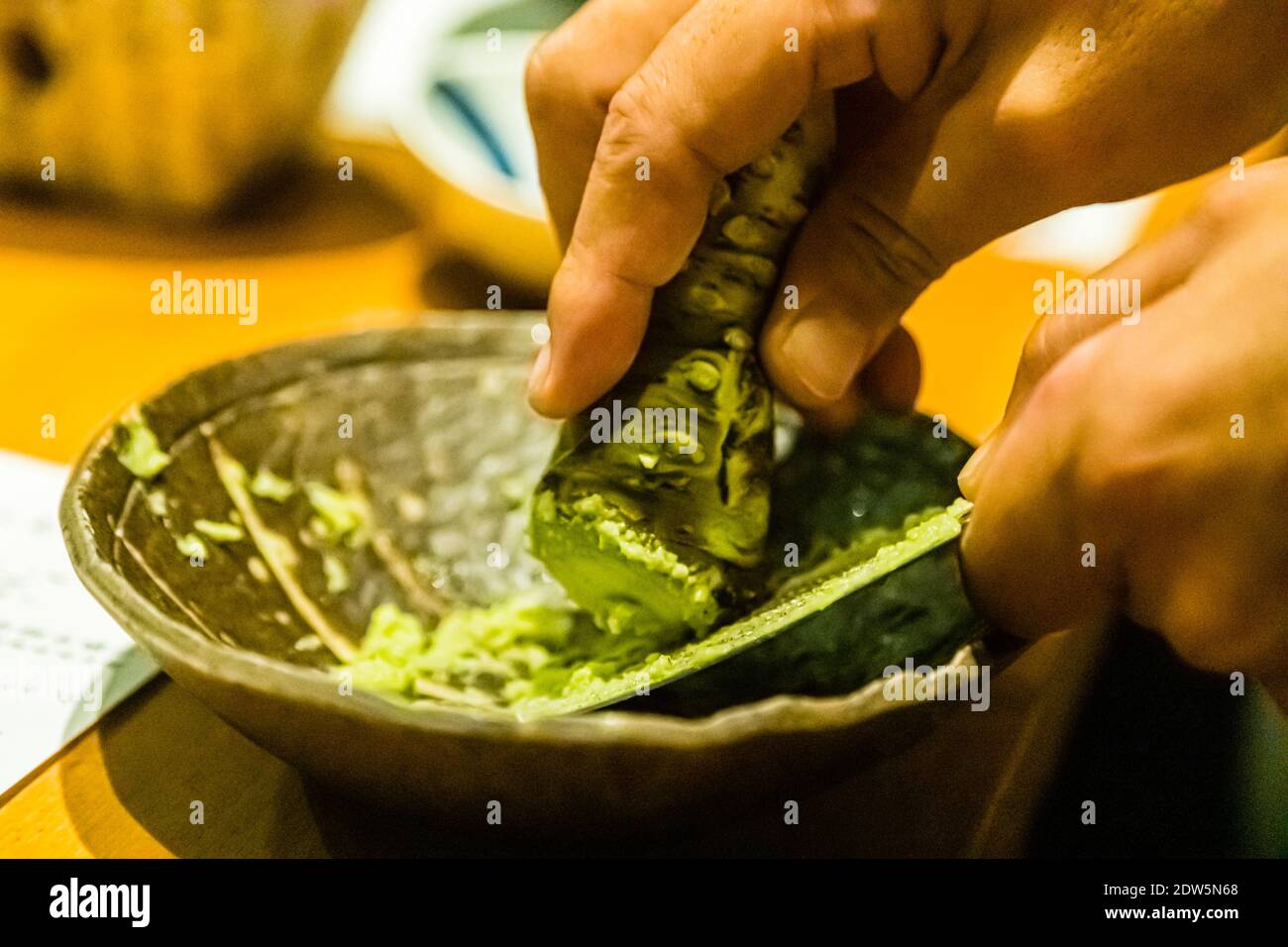 Wasabi wird auf einer Edelstahlreibe gerieben. Frischgerieben entfaltet Wasabi nach rund fünf Minuten seine stärkste Schärfe Banque D'Images