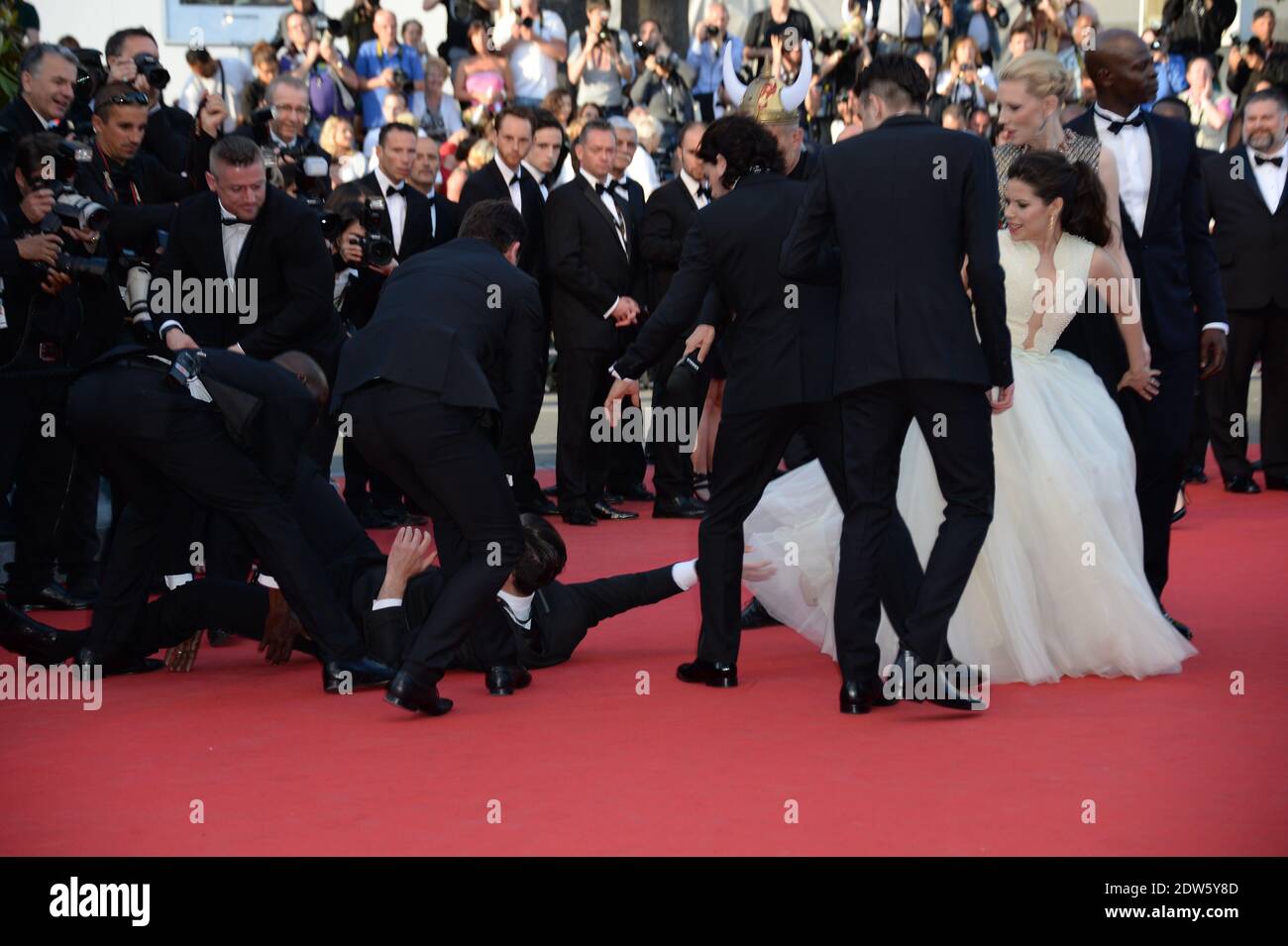 Le journaliste ukrainien Vitalii Sediuk envahit le tapis rouge en essayant de saisir la cheville de l'America Ferrera et est tenu par la sécurité lors de la projection du Dragon 2 au Palais des Festivals de Cannes, le 16 mai 2014, dans le cadre du 67ème Festival de Cannes. Photo de Nicolas Briquet/ABACAPRESS.COM Banque D'Images