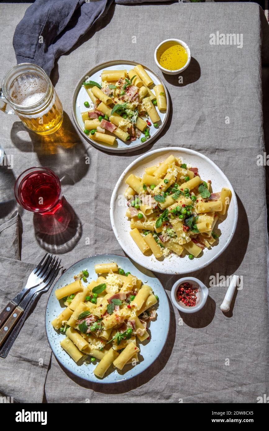 Recette italienne pâtes tortilloni au pois vert, feuilles de menthe, bacon fumé et fromage. Banque D'Images