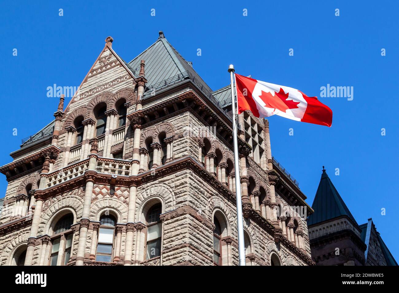 Toronto, Canada - 16 mai 2020 : drapeau canadien agitant avec l'ancien hôtel de ville en arrière-plan à Toronto, Canada. Banque D'Images