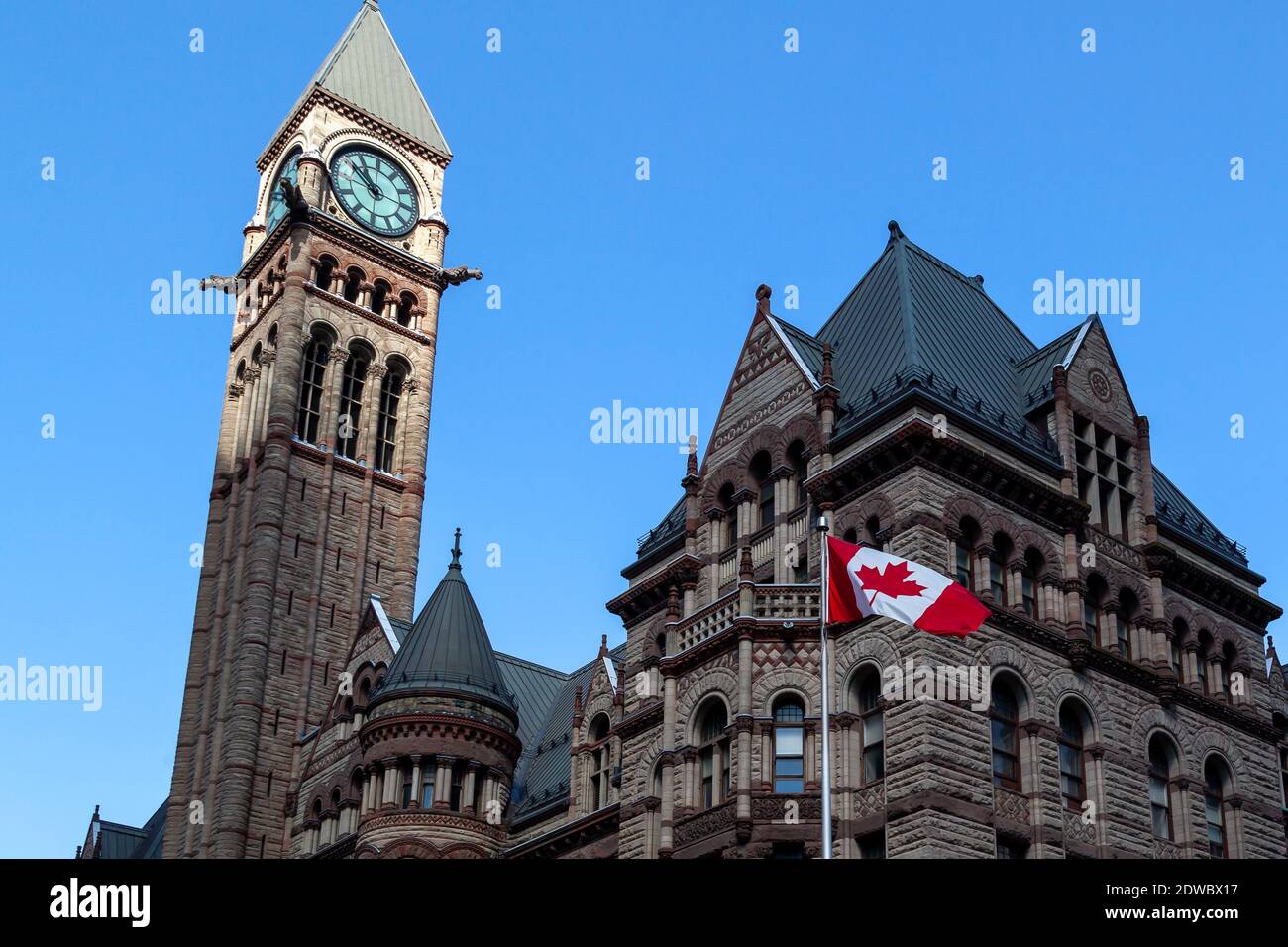 Le drapeau canadien agité avec le vieil hôtel de ville en arrière-plan à Toronto, Canada. Banque D'Images