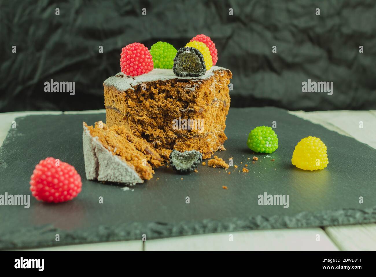 Bonbons et gâteau en gelée multicolores. Gâteau mordu. Le processus de manger un gâteau. Décoration et décoration de gâteaux et pâtisseries Banque D'Images