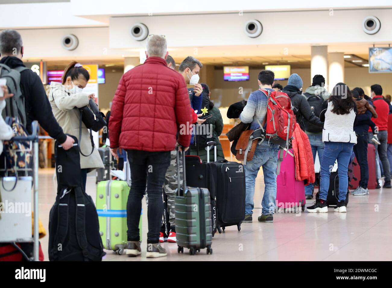 Hambourg, Allemagne. 23 décembre 2020. Les voyageurs font la queue au  comptoir d'enregistrement de l'aéroport de Hambourg la veille de la veille  du Salut. L'Allemagne est dans une zone de confinement pour