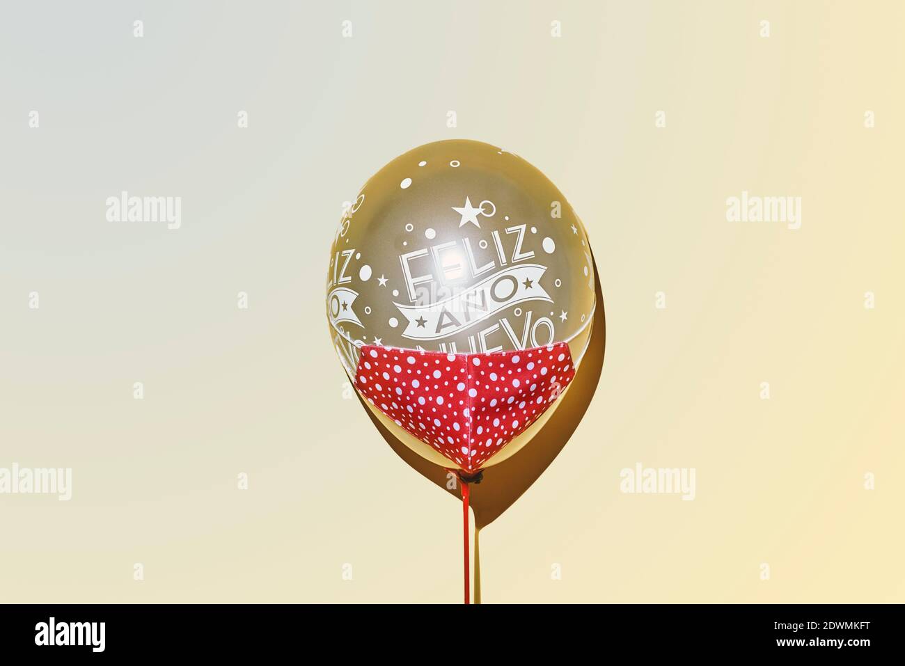 Un Ballon D Or Portant Un Masque Rouge Avec Le Texte Bonne Annee Ecrit En Espagnol Sur Fond Jaune Photo Stock Alamy
