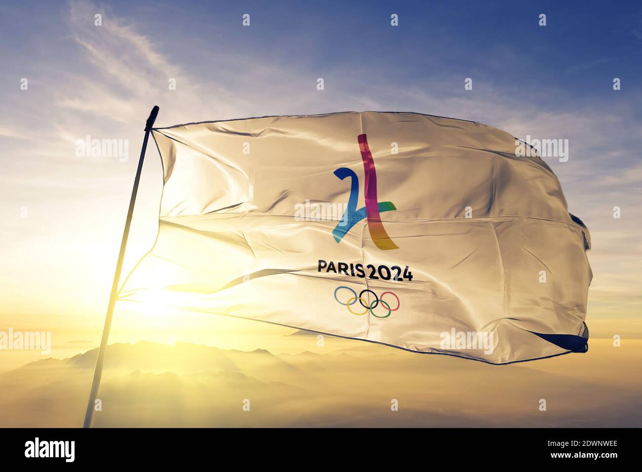 Drapeau du logo des Jeux Olympiques d'été 2024 qui s'agite au lever du soleil brouillard Banque D'Images