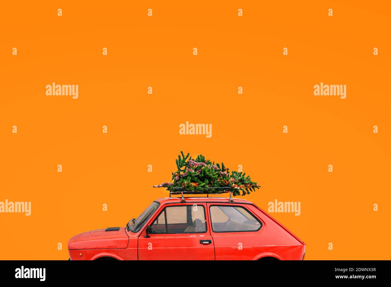 Voiture avec un arbre de Noël sur le toit. Arrière-plan de Noël avec espace de copie. Livraison de marchandises, voyages du nouvel an et visites. Banque D'Images