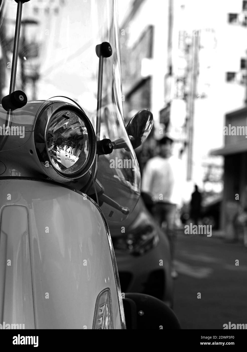 Détail des phares avant du stationnement de Scooter italien classique sur la rue urbaine. Mise au point sélectionnée. Banque D'Images