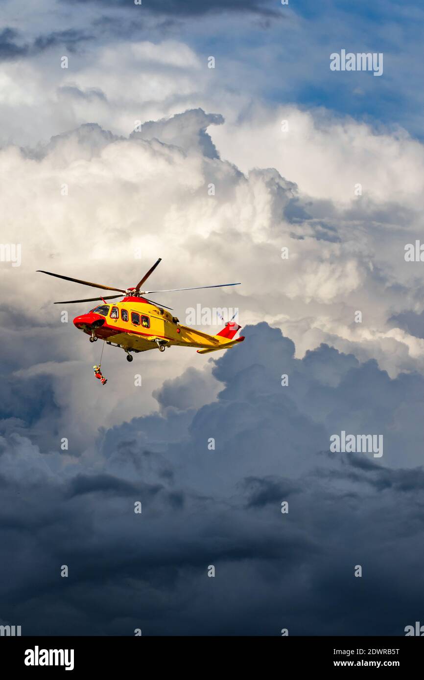 Sauvetage en hélicoptère en action dans le ciel nuageux Banque D'Images