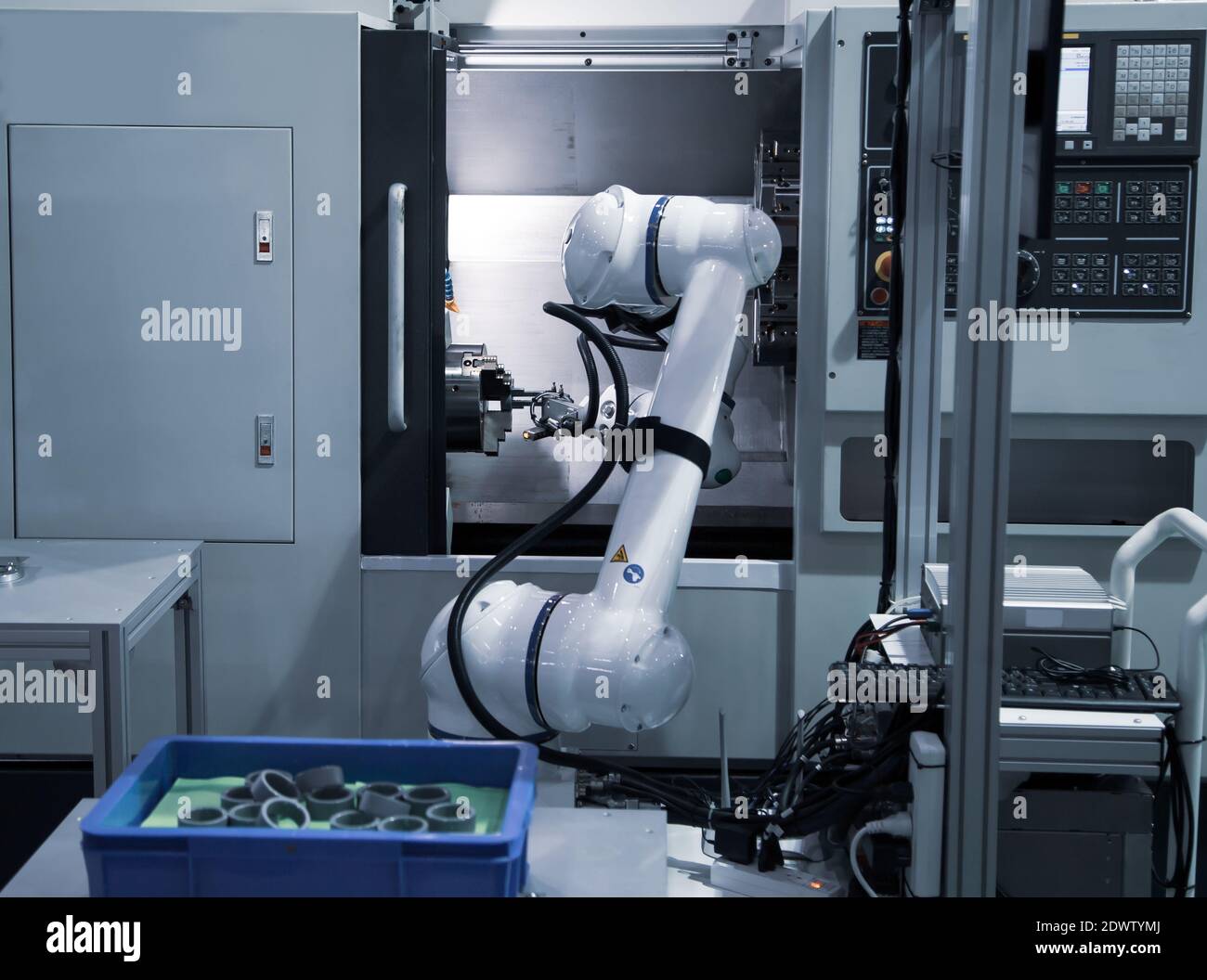 Robot industriel à processus automatisé chargeant la pièce métallique sur la machine CNC. Fabrication industrielle Banque D'Images