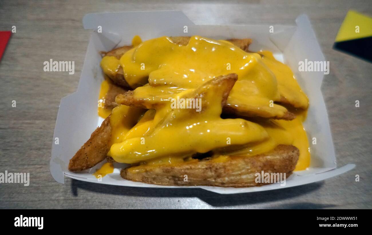 Des quartiers de pommes de terre au fromage sur la table en bois. Mise au point sélective Banque D'Images