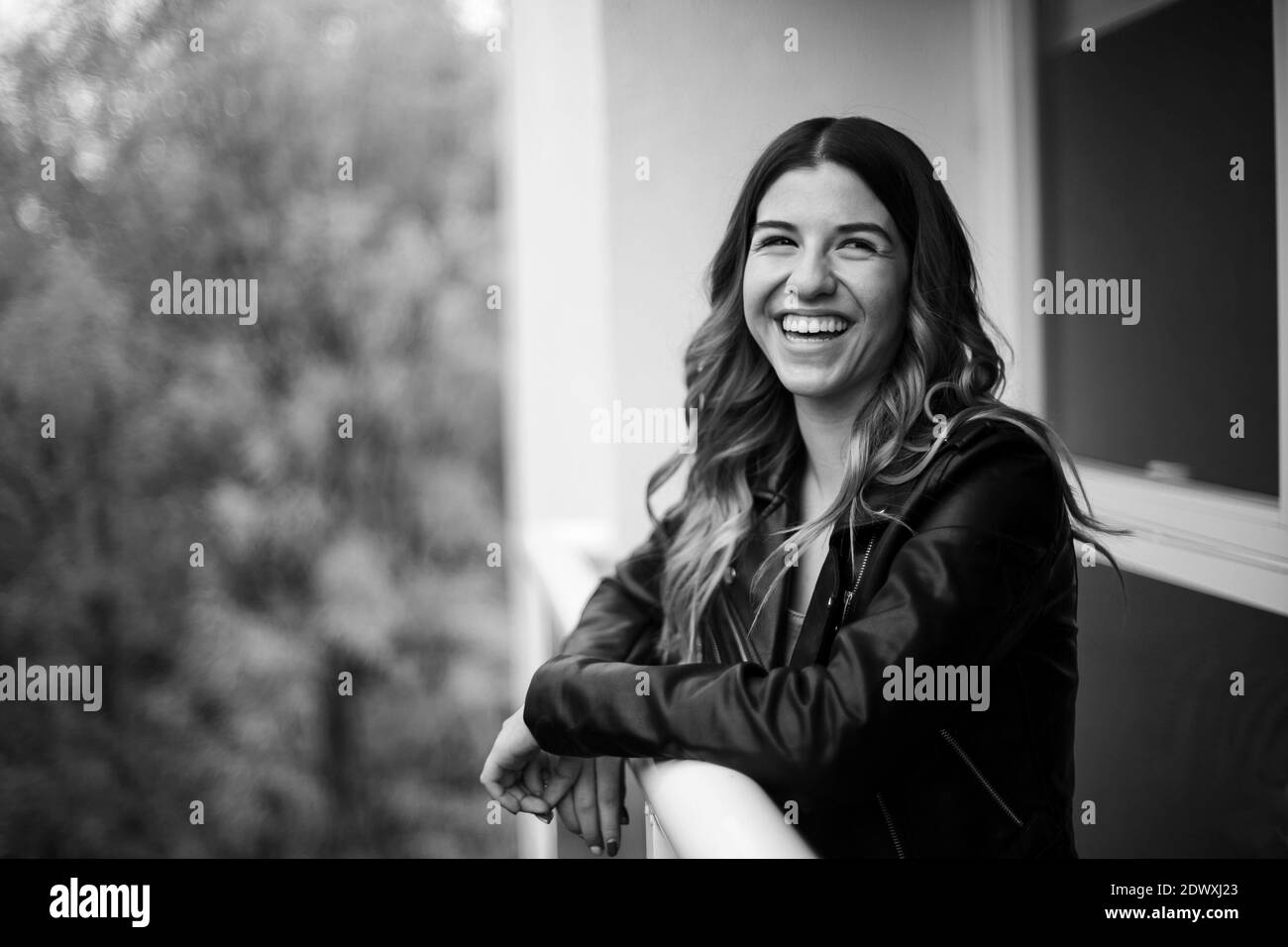Portrait d'une jeune femme sur pied noir et blanc, elle est sur son balcon. À l'extérieur de votre service Banque D'Images