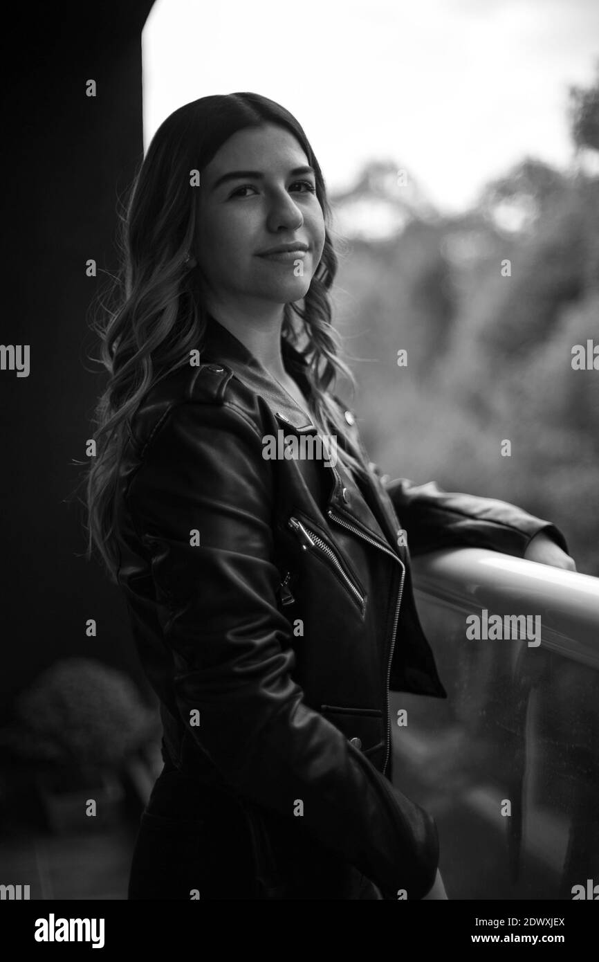 Portrait d'une jeune femme sur pied noir et blanc, elle est sur son balcon. À l'extérieur de votre service Banque D'Images