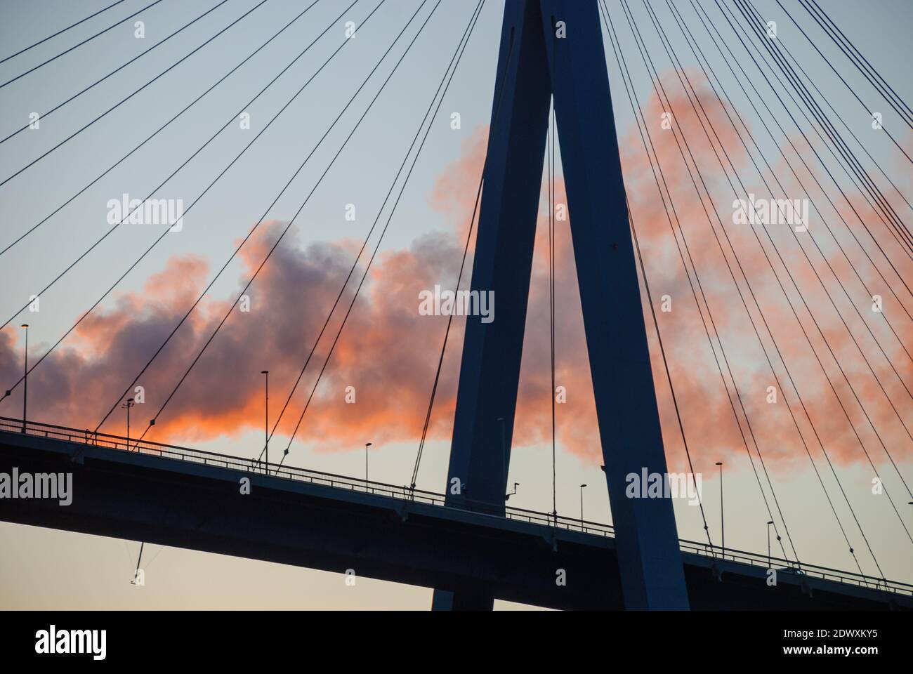 Hambourg, Allemagne: Pylône du pont Koehlbrand à Hambourg dans le ligh du coucher du soleil, en arrière-plan fumée d'une cheminée d'usine Banque D'Images