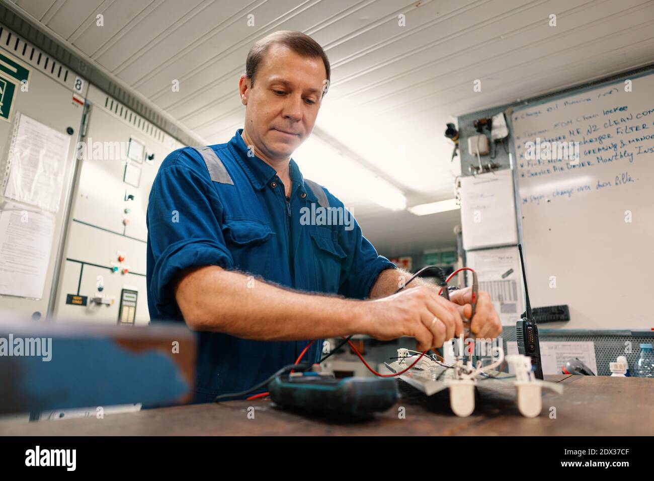 Ingénieur en électricité marine dans la salle de commande des moteurs, ECR. Il travaille en atelier Banque D'Images