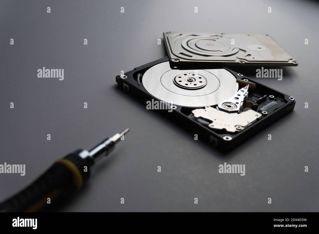 Vue en grand angle du disque dur par l'outil de réparation sur fond gris  Photo Stock - Alamy