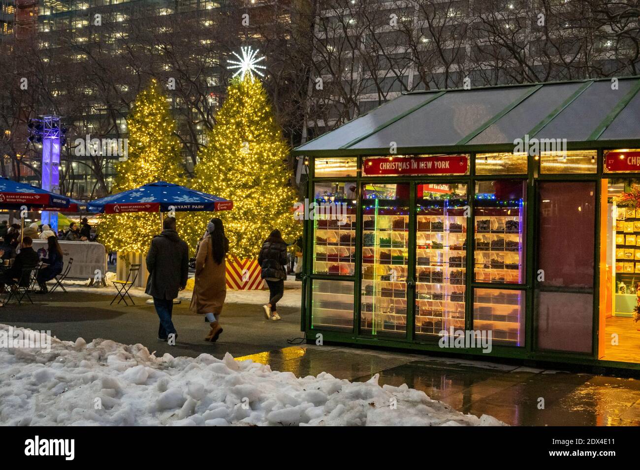Les gens qui apprécient les arbres de Noël illuminés dans le village de vacances de Bryant Park lors d'une soirée hivernale, New York City, États-Unis Banque D'Images
