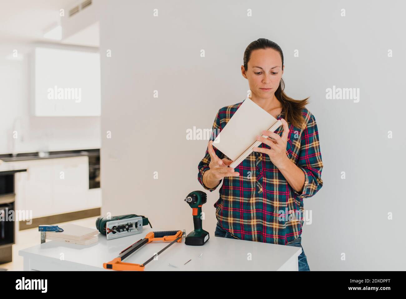 Femme adulte de taille moyenne faisant du bricolage tout en étant debout à la maison Banque D'Images