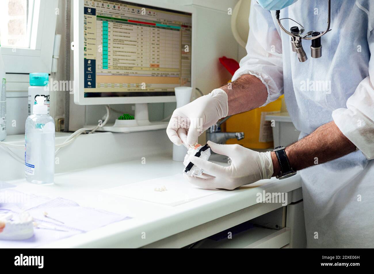 Dentiste masculin préparant une prothèse dentaire en se tenant à la clinique Banque D'Images