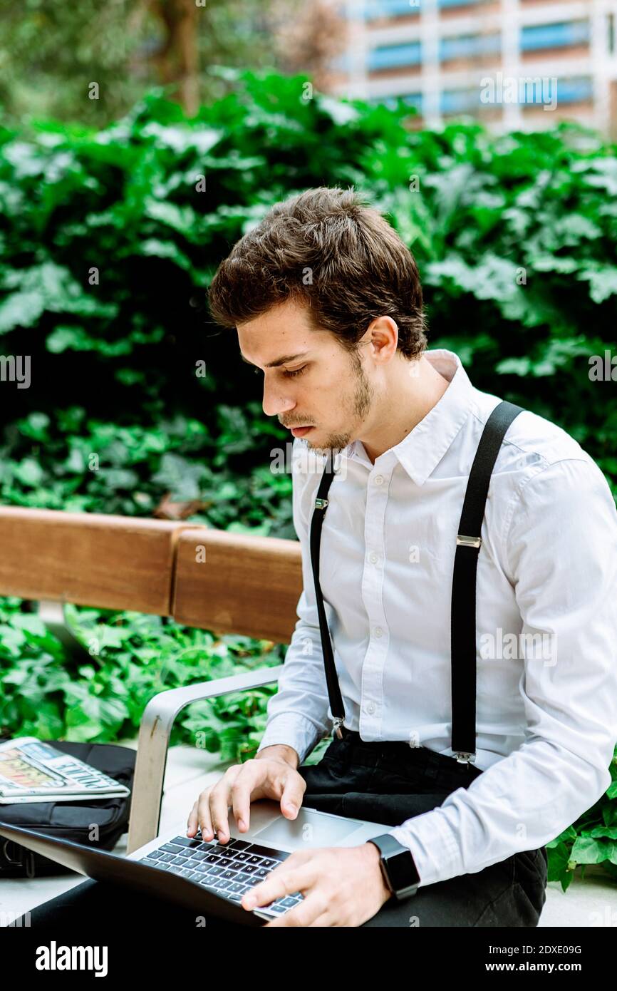 Jeune homme d'affaires travaillant sur un ordinateur portable à l'extérieur Banque D'Images