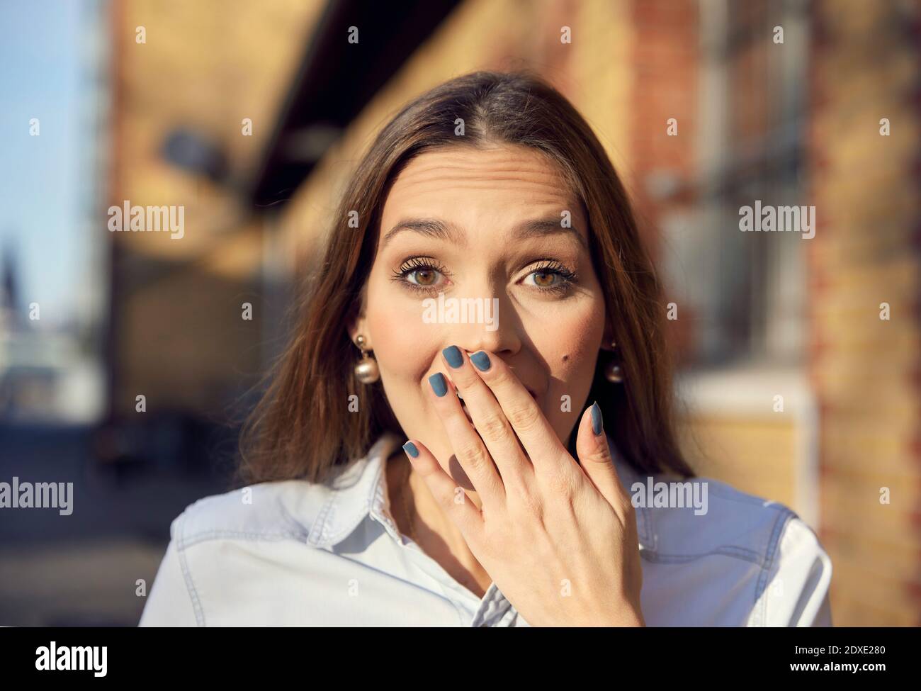 Surpris femme d'affaires avec main sur la bouche en regardant à l'extérieur Banque D'Images