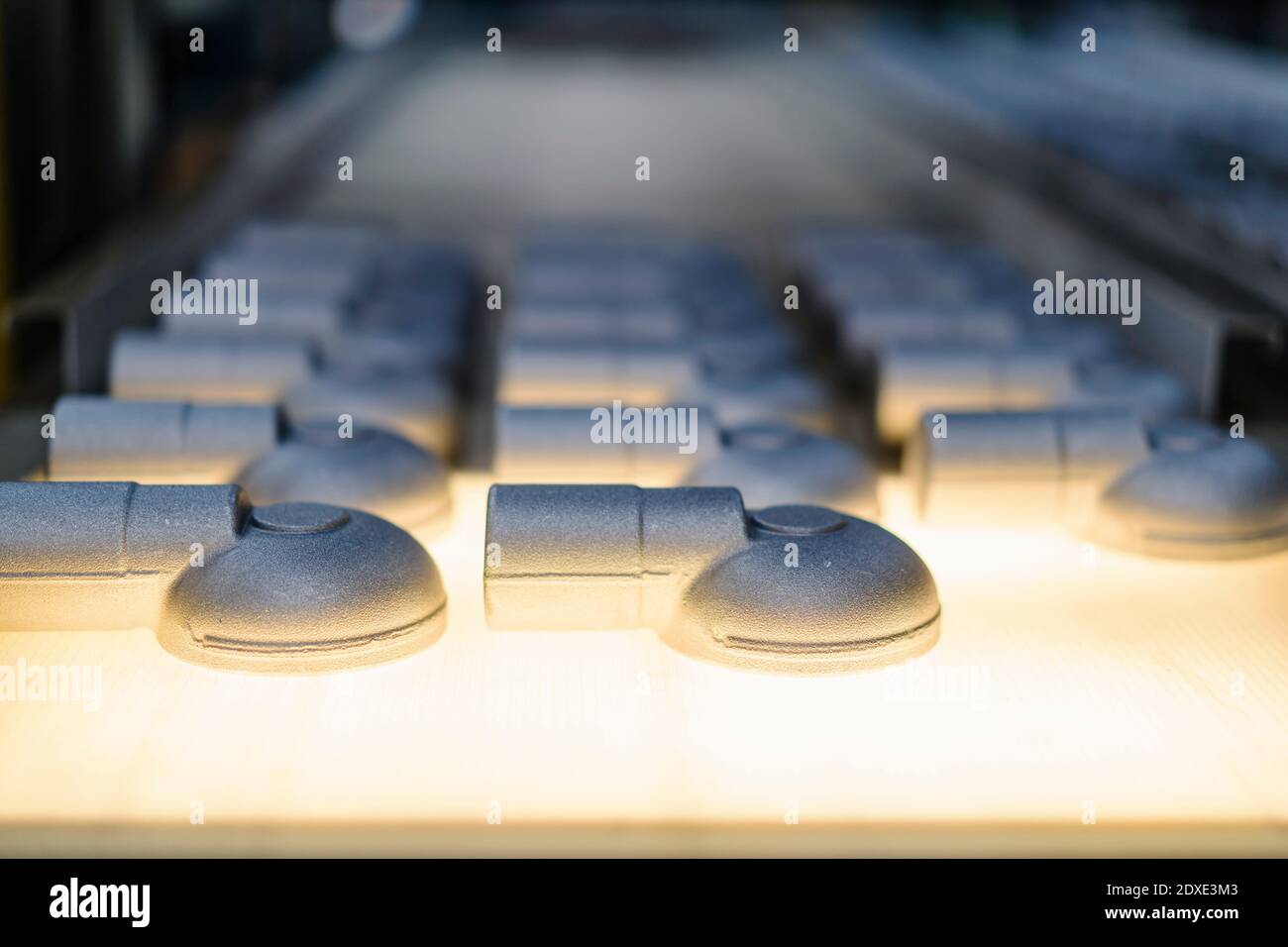 Produit sur courroie transporteuse sur chaîne de production en usine éclairée Banque D'Images