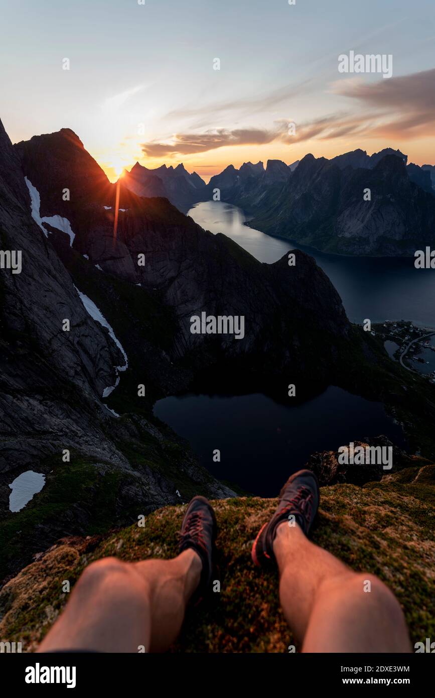 Homme portant une chaussure de sport assis en montagne à Reinebringen. Lofoten, Norvège Banque D'Images