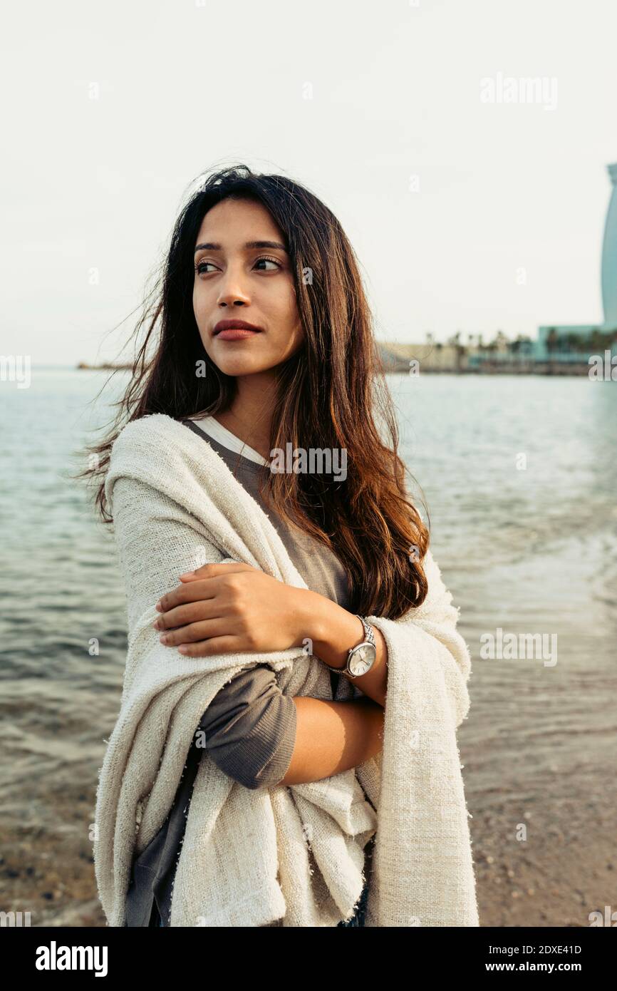 Femme en contemplant les bras croisés en regardant la plage Banque D'Images
