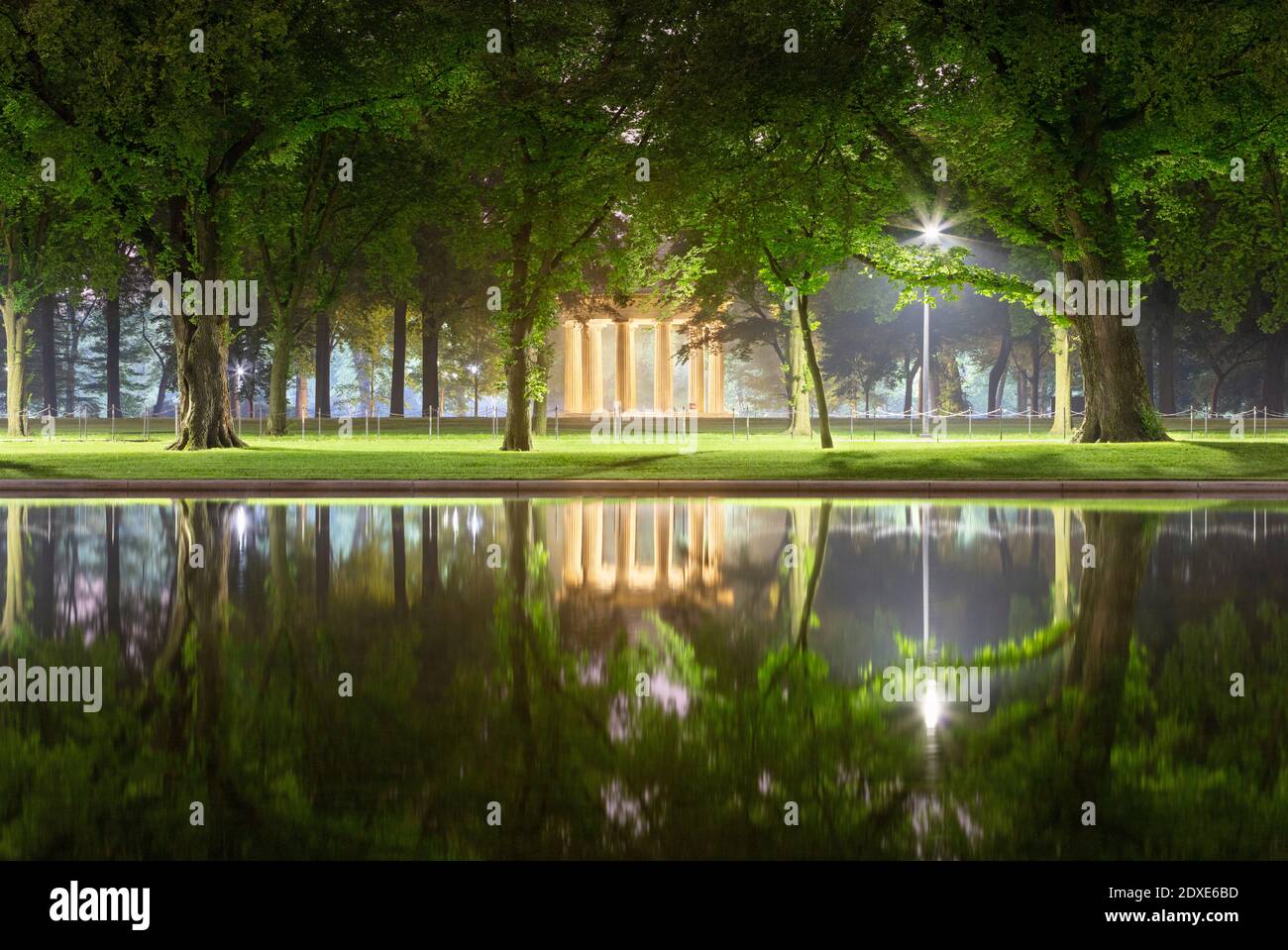 États-Unis, Washington DC, arbres se reflétant dans le Lincoln Memorial Reflecting Pool la nuit avec District of Columbia War Memorial en arrière-plan Banque D'Images