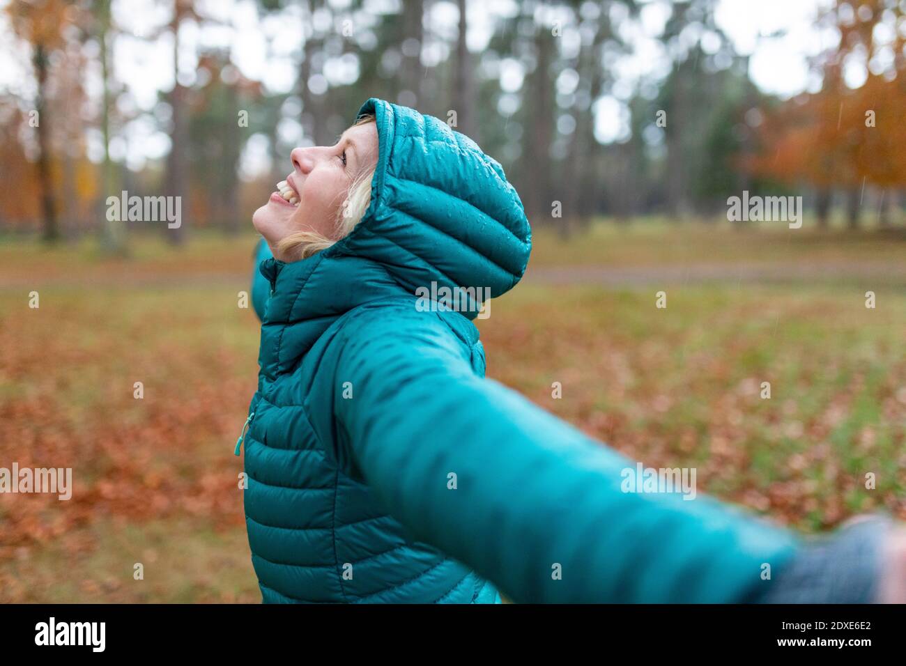 Une femme heureuse avec des bras débordés se mouille à Cannock Chase Banque D'Images