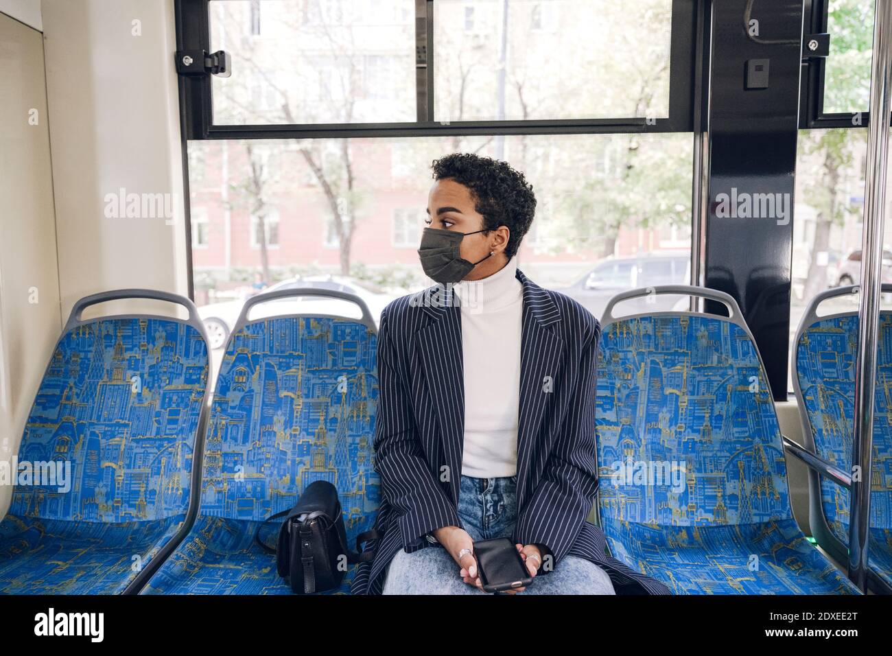 Jeune femme d'affaires voyageant en bus pendant COVID-19 Banque D'Images Jeune femme d'affaires voyageant en bus pendant COVID-19 Banque D'Images