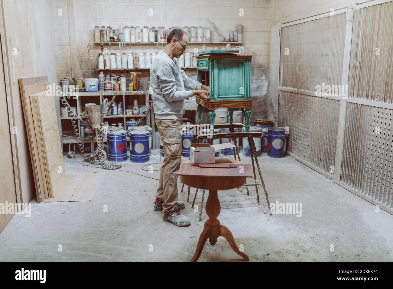 Travailleur manuel travaillant sur des meubles anciens lorsqu'il se trouve à l'atelier Banque D'Images