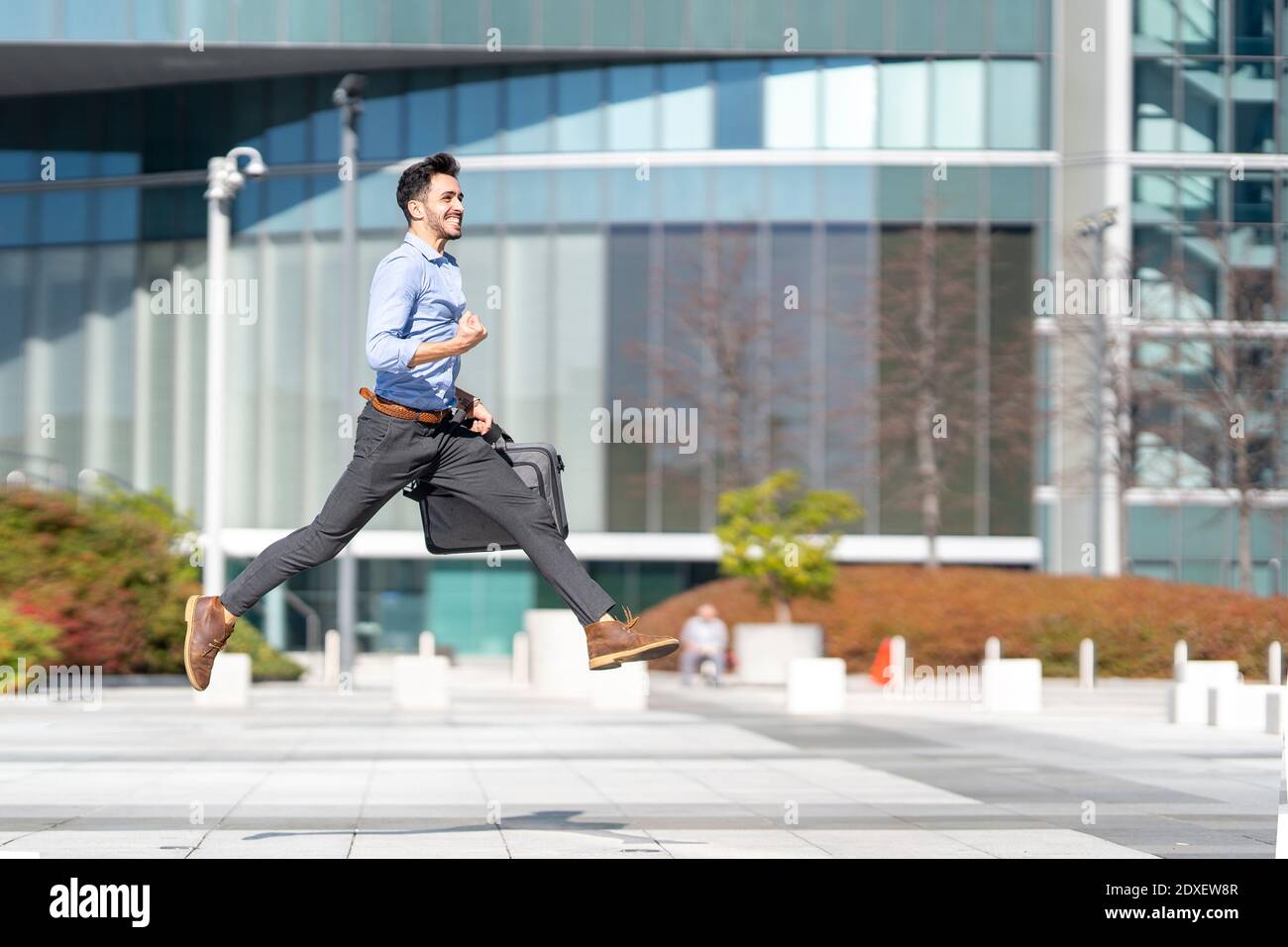 Un homme d'affaires heureux applaudisse lorsqu'il court sur une piste de jogging Banque D'Images