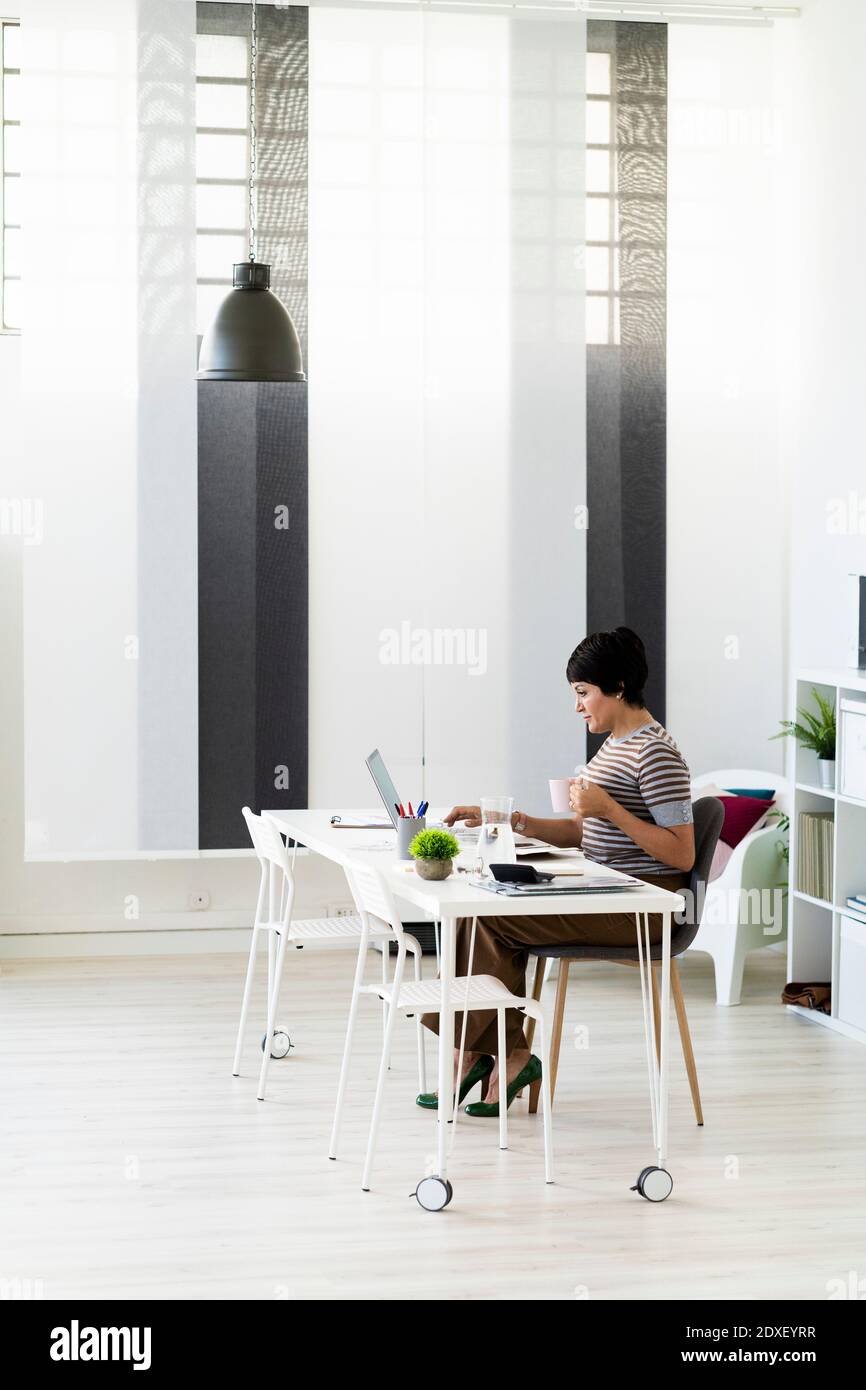 Femme d'affaires travaillant seule à une table de bureau Banque D'Images