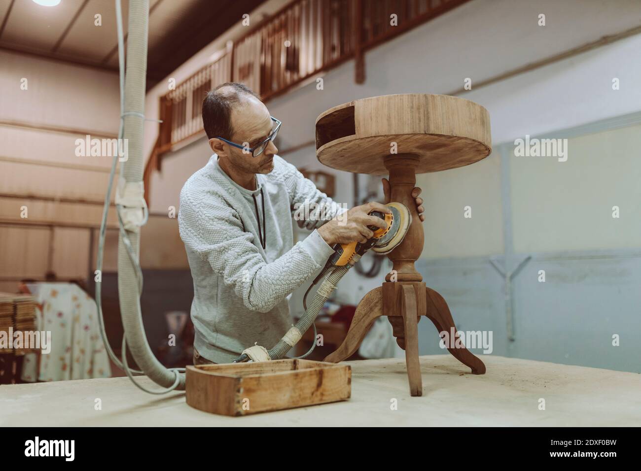 Menuisier utilisant une table de ponceuse pendant le travail en atelier Banque D'Images