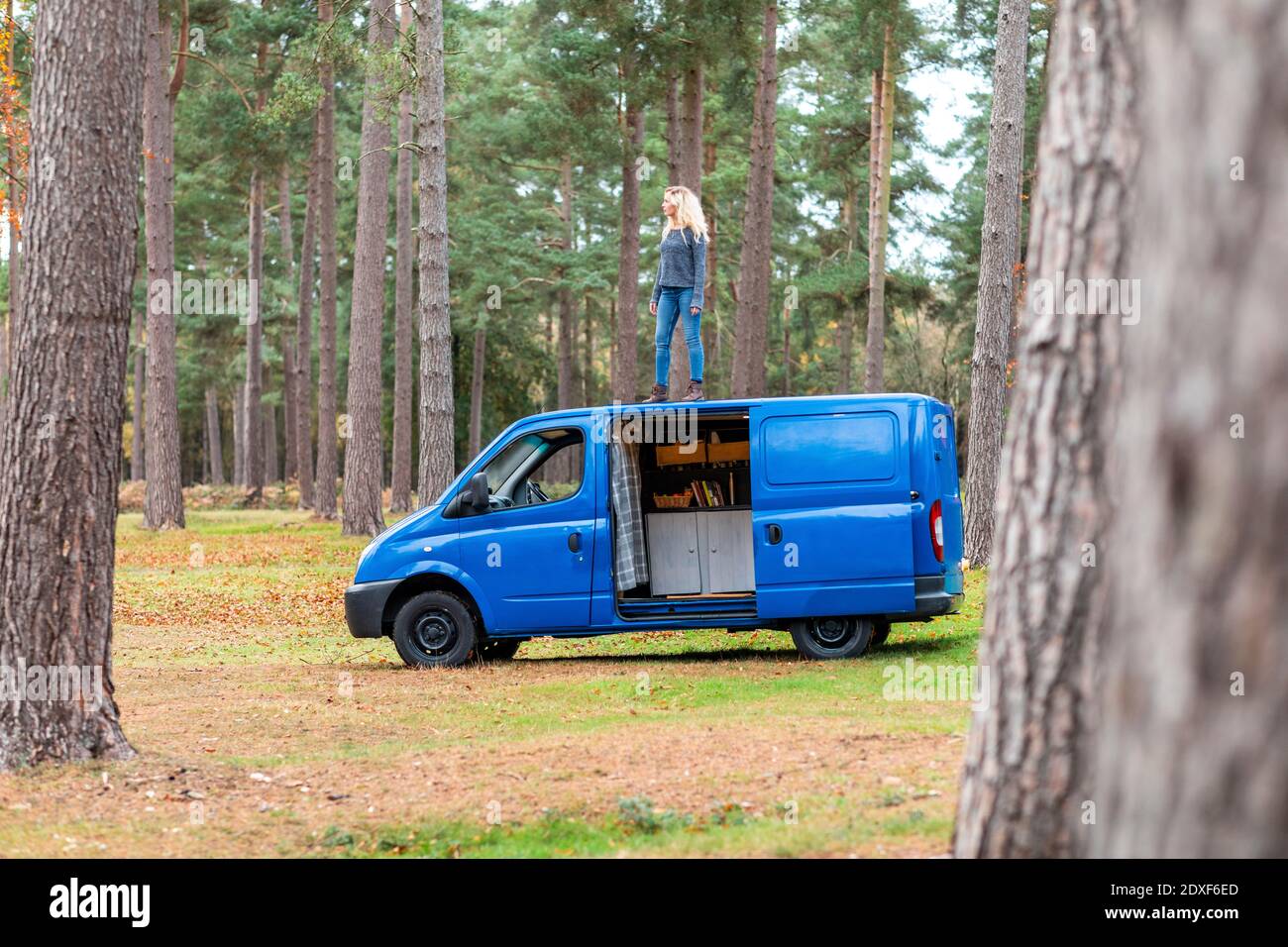 Femme avec une attitude cool debout sur le dessus de la camionnette de camping Au Cannock Chase Banque D'Images