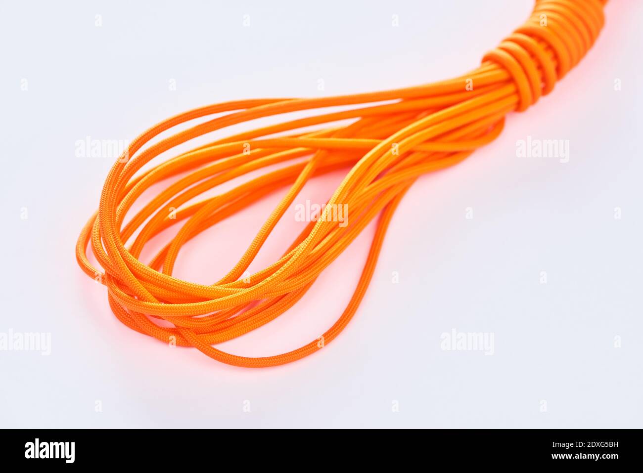 Gros plan sur une bobine de fil de nylon orange sur blanc arrière-plan Banque D'Images