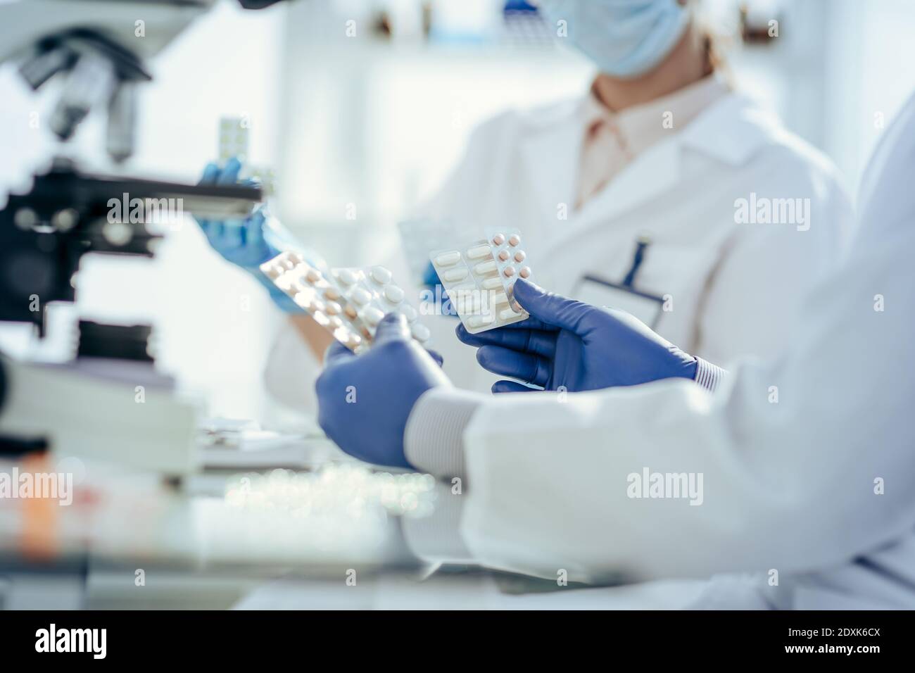 scientifiques avec des échantillons de nouveaux médicaments assis à une table de laboratoire. Banque D'Images
