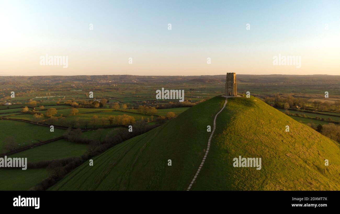 Vue aérienne du lever du soleil tôt le matin au-dessus de Glastonbury Tor avec les champs Somerset ci-dessous. Banque D'Images