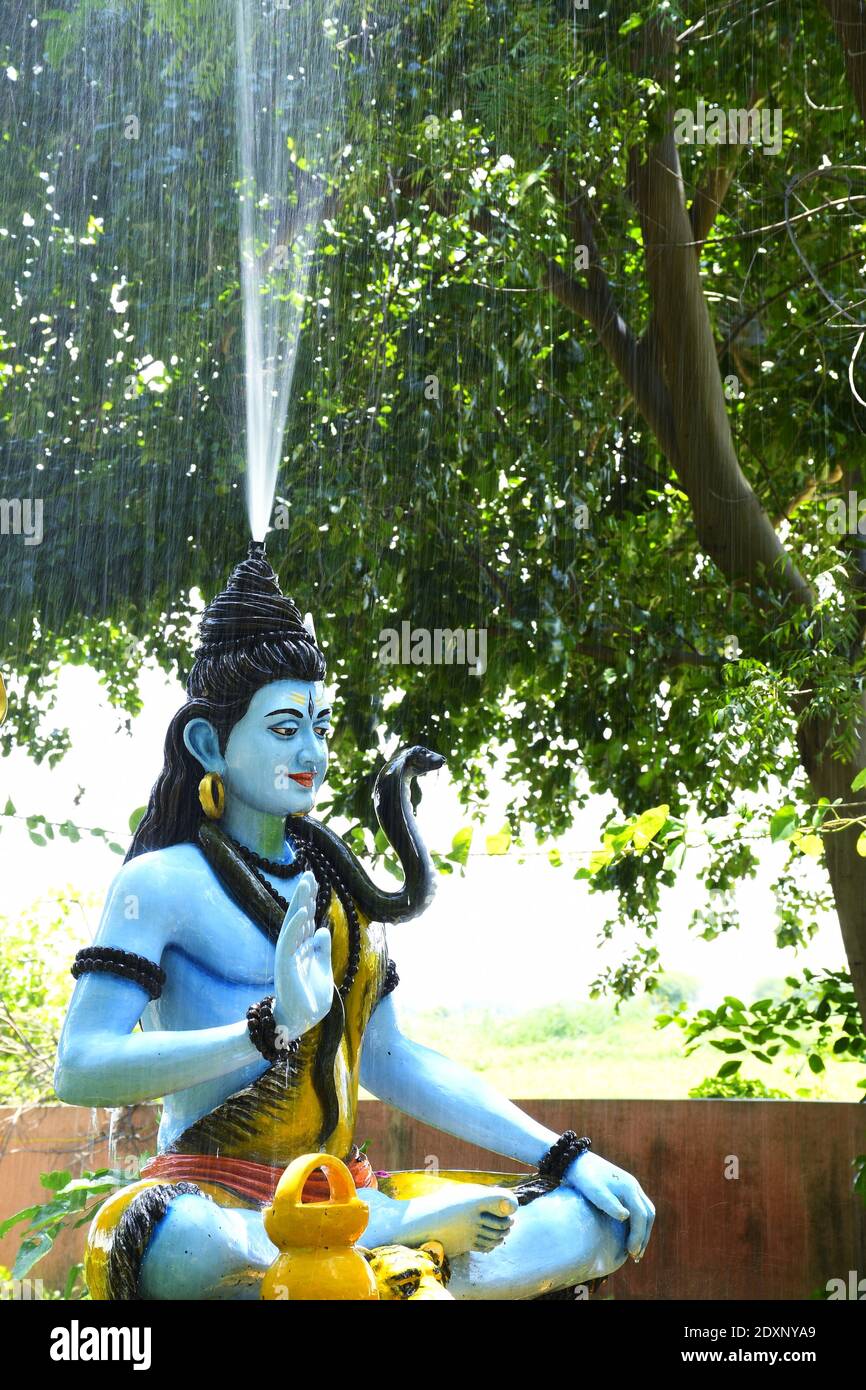 Statue du seigneur Shiva et pluie de fond Banque D'Images
