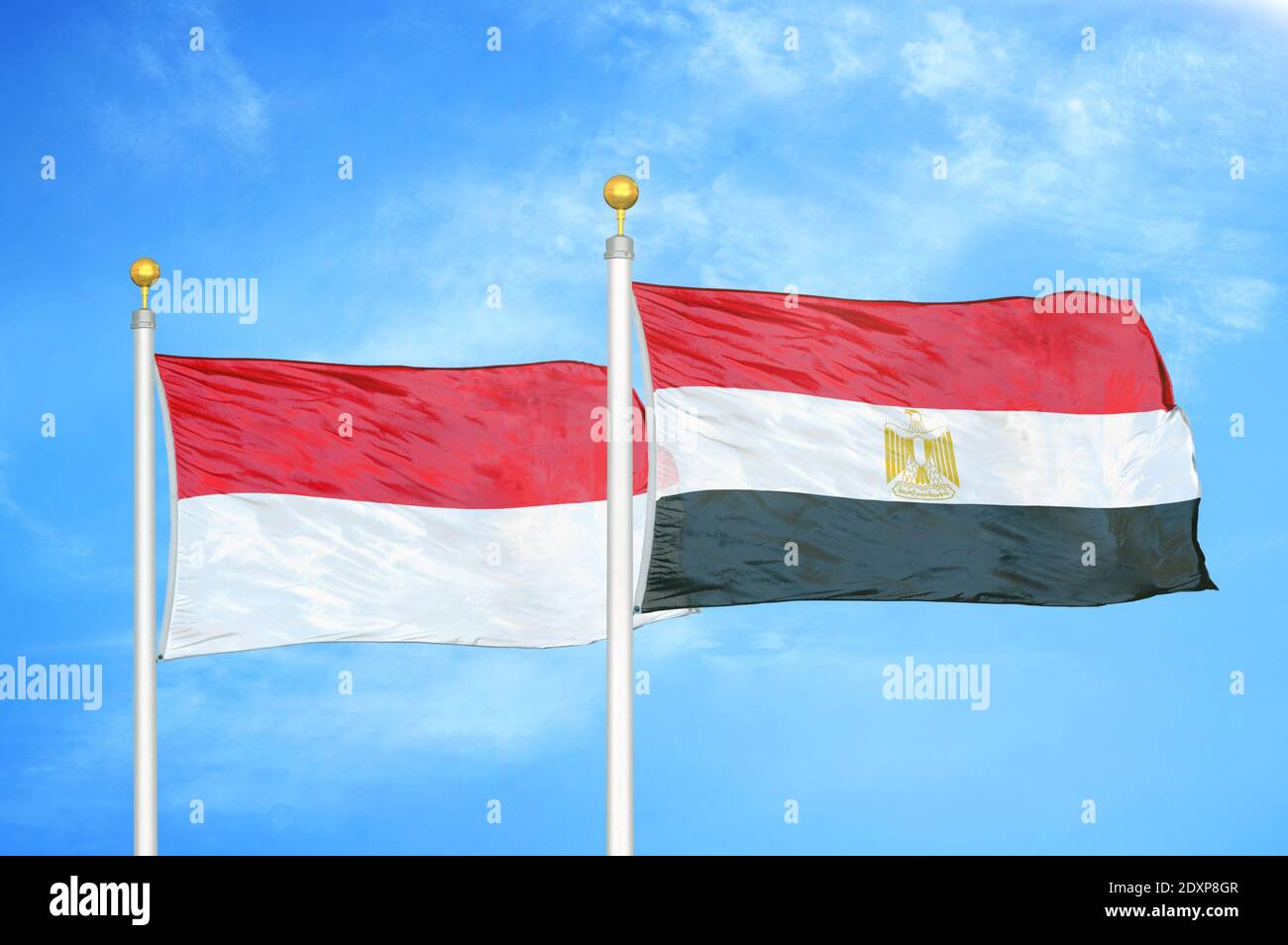 Indonésie et Égypte deux drapeaux sur les mâts de drapeaux et bleu nuageux ciel Banque D'Images